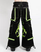 Load image into Gallery viewer, Black wide-leg cargo pants with lime green contrast stitching, decorative straps, and a large lime green biohazard graphic on the legs.