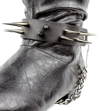 Load image into Gallery viewer, close up shot of black boot displaying black boot strap  that has two rows of multiple silver sharp pointy spike studs and hanging silver chain