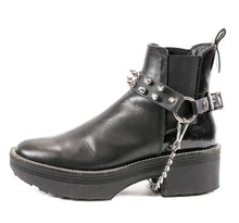 Load image into Gallery viewer, black ankle boot displaying black leather boot strap with two rows of silver tree spikes, single silver o ring and silver hanging chain