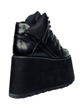 Load image into Gallery viewer, back view of black vegan leather platform shoe with EVA platform. Shoe looks like a sneaker, but super tall! Shoe has nylon details and mesh lining. Bottom of platform has a "fanned" grip to make the platform more stable.