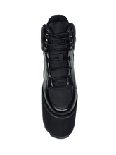 Load image into Gallery viewer, top view of black vegan leather platform shoe with EVA platform. Shoe looks like a sneaker, but super tall! Shoe has nylon details and mesh lining. Bottom of platform has a "fanned" grip to make the platform more stable.