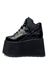 Load image into Gallery viewer, outer view of black vegan leather platform shoe with EVA platform. Shoe looks like a sneaker, but super tall! Shoe has nylon details and mesh lining. Bottom of platform has a "fanned" grip to make the platform more stable.