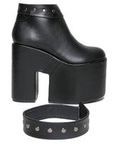 Load image into Gallery viewer, outer side view of black vegan leather super tall 6" heel, 4" platform sleep design boot. Boot has a rivet studded strap that wraps around and is removable or attachable with Velcro. Boot has black EVA platform.