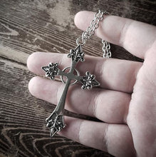 Load image into Gallery viewer, back side of Silver colored zinc alloy vampire cross necklace with red cubic zirconia gem in center of cross.