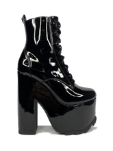 Load image into Gallery viewer, outer view of Black vegan shiny patent leather tall military style platform boot with black cotton laces and black inner zipper. Front of platform has a fanned grip for better stability when walking.
