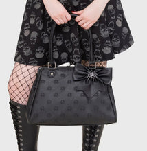 Load image into Gallery viewer, Person wearing a black dress with skull pattern, black boots, and holding a black handbag on a white background
