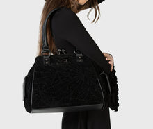 Load image into Gallery viewer, Model holding a black textured handbag against a white background
