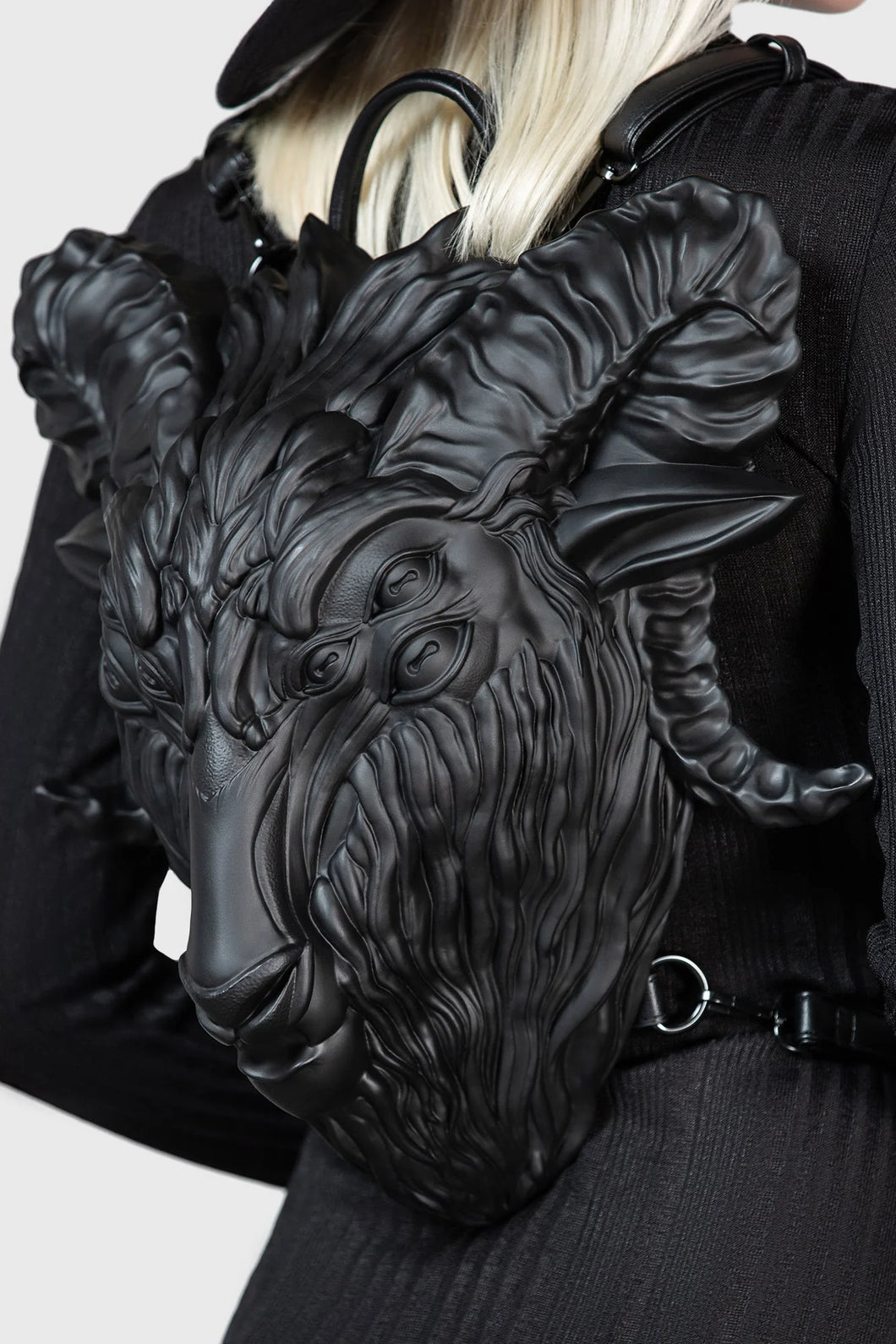 Black leather backpack with goat head design worn by a model