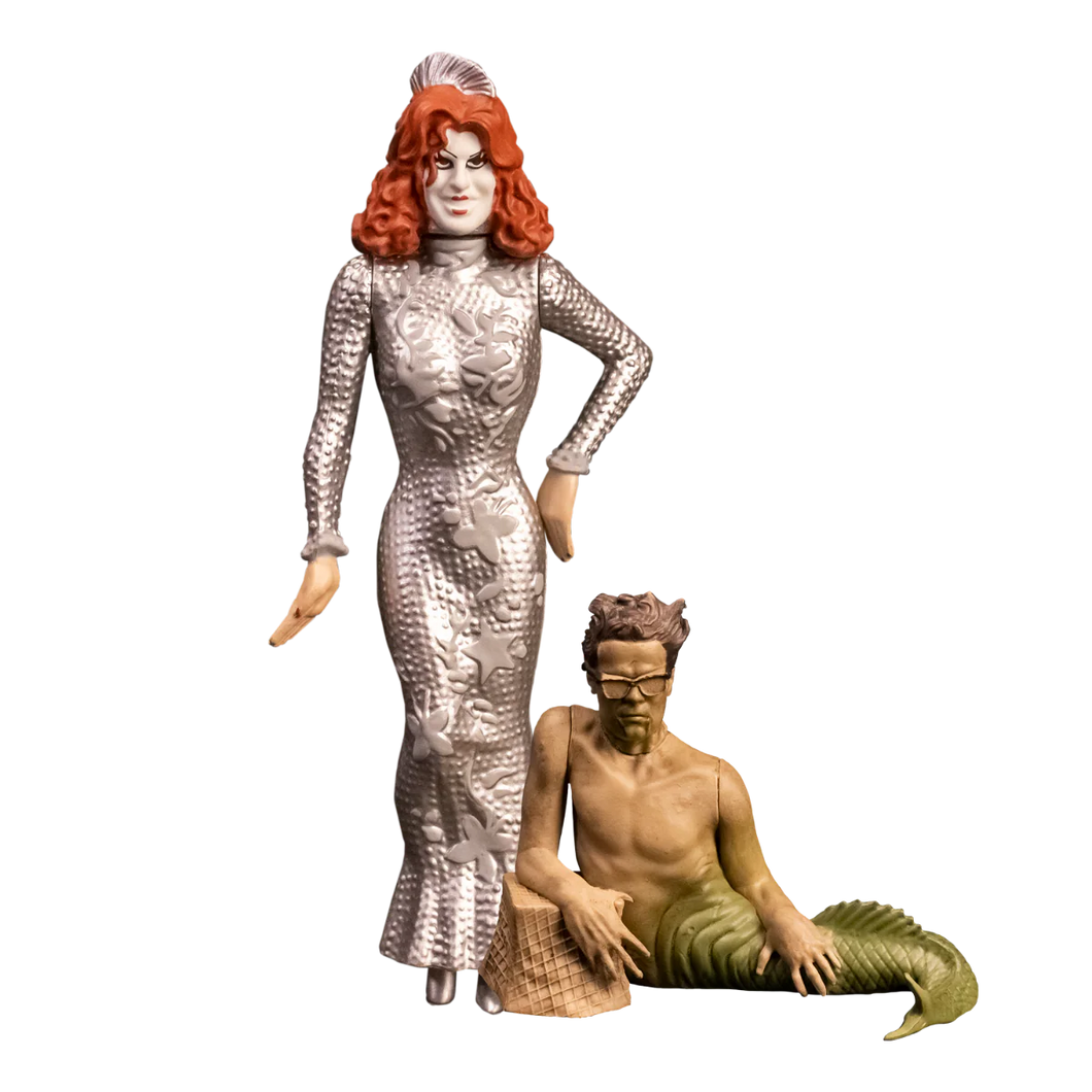Two figurines, one in a silver dress and the other in a mermaid costume, on a white background