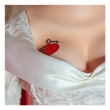 Load image into Gallery viewer, Doll is clothed with a white long sleeve wedding dress and black choker accessory. Has tattoo on right breast of a red heart with a dagger stabbed in it and the text &quot;chucky&quot; above the heart.
