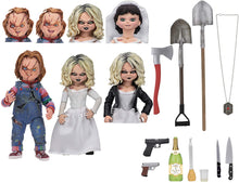 Load image into Gallery viewer, Figures of Chucky and Tiffany, based on the 1998 film Bride of Chucky. Accessories include: 6 interchangeable heads, 2 shovels, 2 pistols, 2 knives, bottle, baster, necklace and more. 
