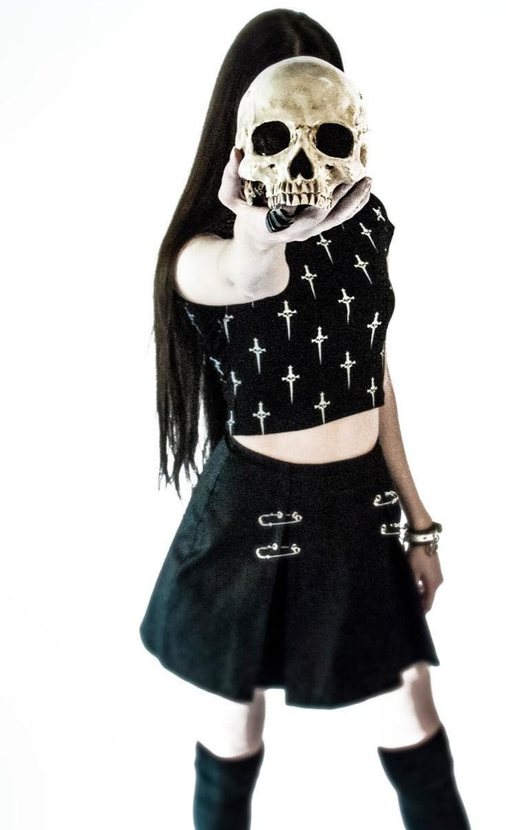 front of Black pleated skirt with front silver safety pin details.