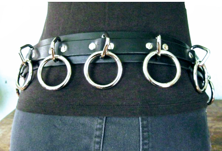 person wearing black leather bondage belt with nine silver hanging o rings