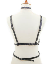 Load image into Gallery viewer, mannequin displaying black leather inverted pentagram shaped eight strap body harness with attached choker and multiple silver o rings

