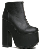 Load image into Gallery viewer, outer view of black vegan leather sleek 6.5&quot; heel boot with silver front zip. Bottom of boot has a fanned front grip for better stability when walking.
