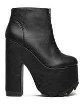 Load image into Gallery viewer, outer view of black vegan leather sleek 6.5&quot; heel boot with silver front zip. Bottom of boot has a fanned front grip for better stability when walking.
