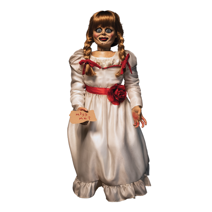 doll wearing white long sleeve dress with red carnation accessory belt. doll is holding parchment paper that reads 