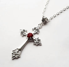 Load image into Gallery viewer, Silver colored zinc alloy vampire cross necklace with red cubic zirconia gem in center of cross.
